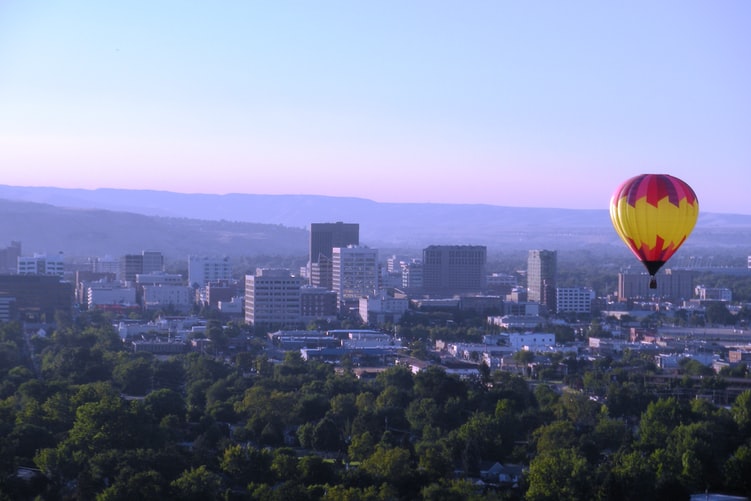 View of Boise from the air with a hot air balloon above it.