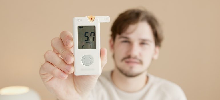 Man demonstrating one of the Self storage qualities his unit has with a thermostat showing 57 degrees Fahrenheit.