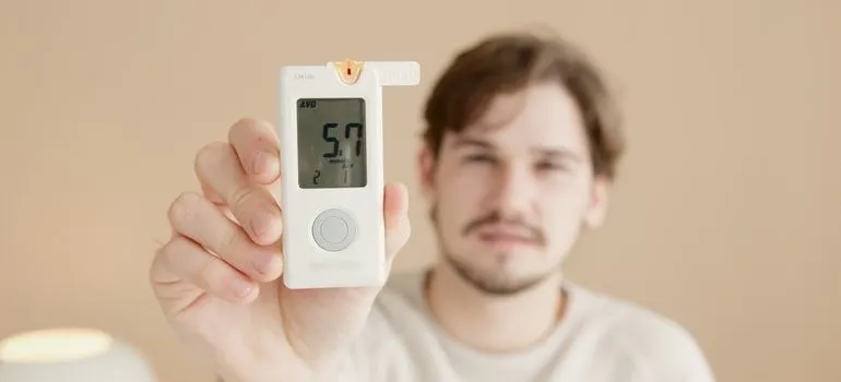 Man demonstrating one of the Self storage qualities his unit has with a thermostat showing 57 degrees Fahrenheit.