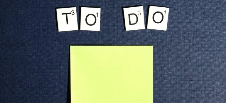 Scrabble tiles spelling "to do" above post-it notes.