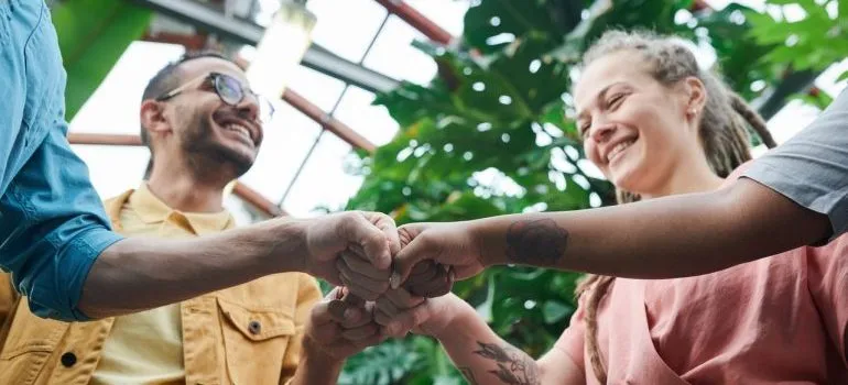 A group of friends fist bumping each other.