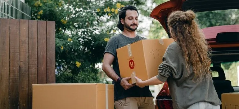 Man helping a woman with moving boxes.