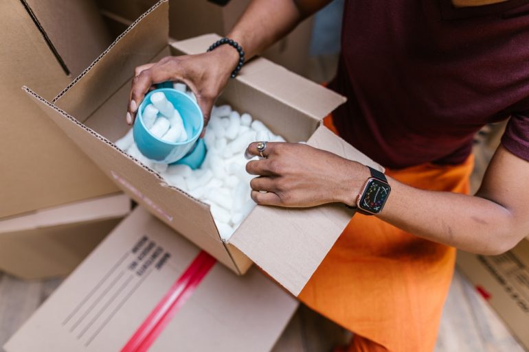 Man packing a blue mug for the move