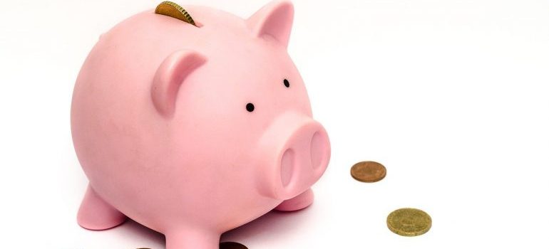 A piggy bank with some coins around it.