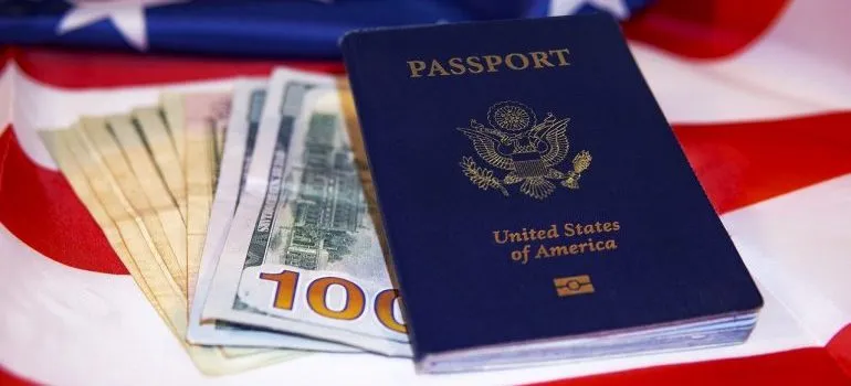 A passport on the US flag and some dollar bills.