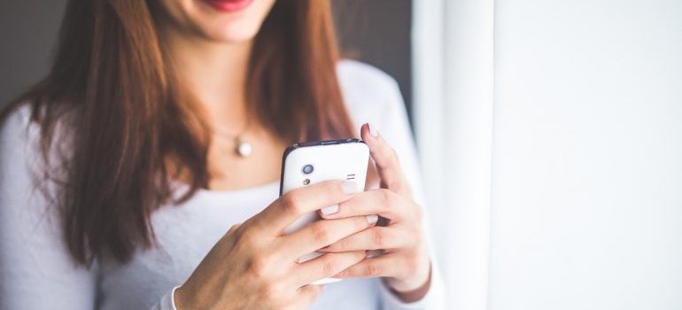 A woman holding a phone, googling how to survive the night before your move