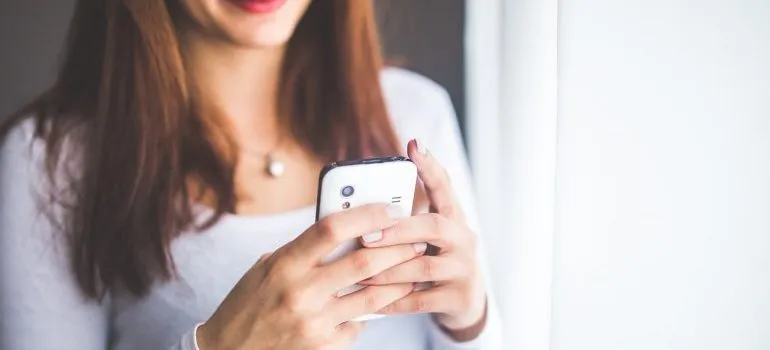 A woman holding a phone, googling how to survive the night before your move