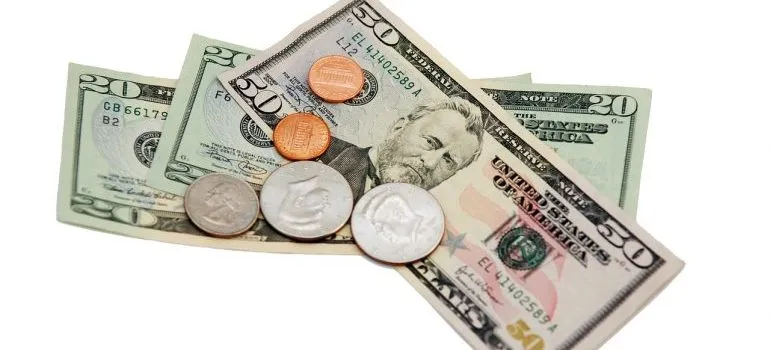 Three dollar bills with some coins on them.