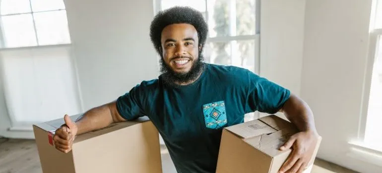 A person holding a box and a thumbs up