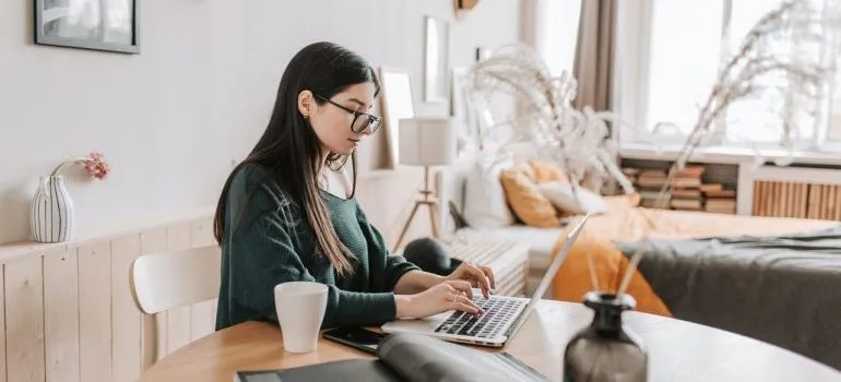 A woman with glasses using a laptop.