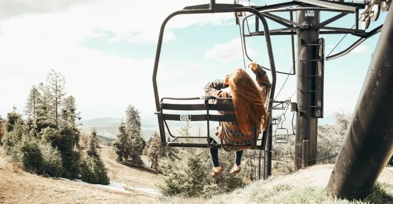 Woman in Brown Long Sleeve Shirt and Black Pants on Black Metal Frame