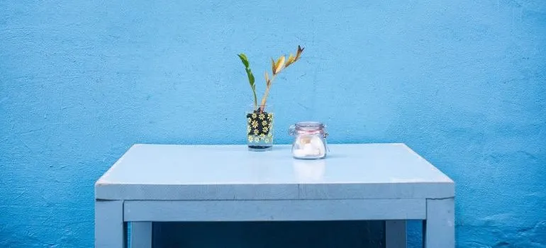 A blue desk in front of a blue wall.