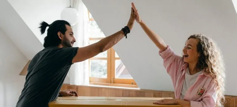 Young couple high fiving each other.