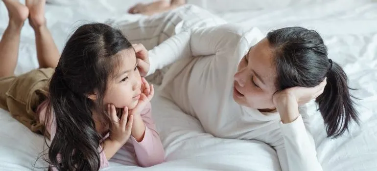 Mother and daughter lying in bed