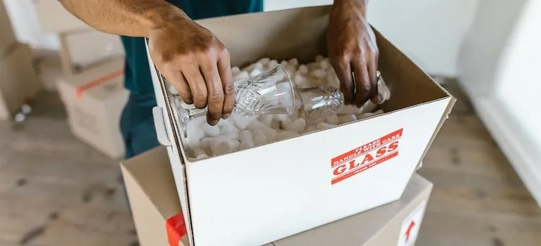 hands putting glasses into a box
