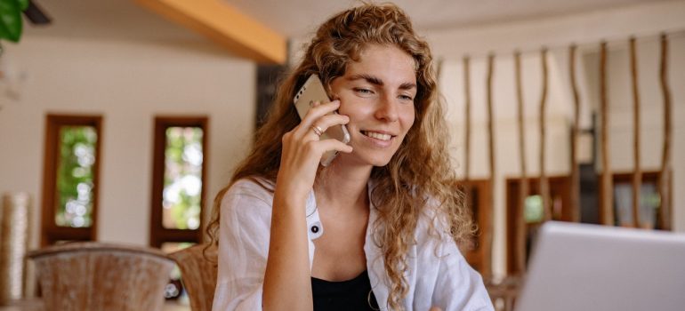 Woman using phone to ask for a binding moving estimate.