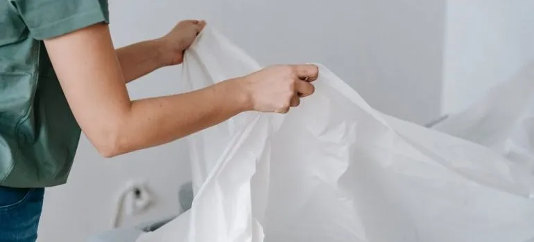 A woman using linens as at-home packing supplies.