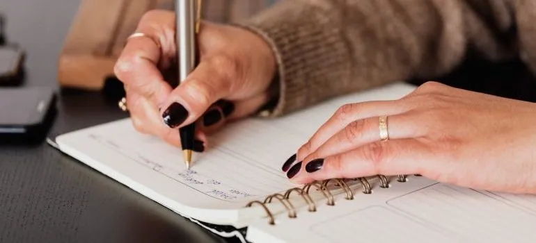 Person planning their move after reading about organizing your new home before unpacking