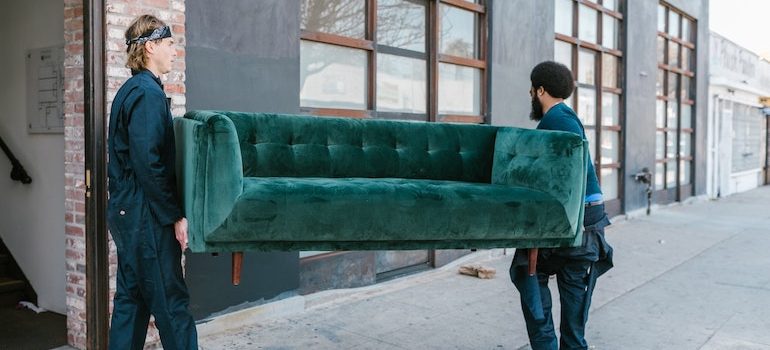 two men carrying a sofa