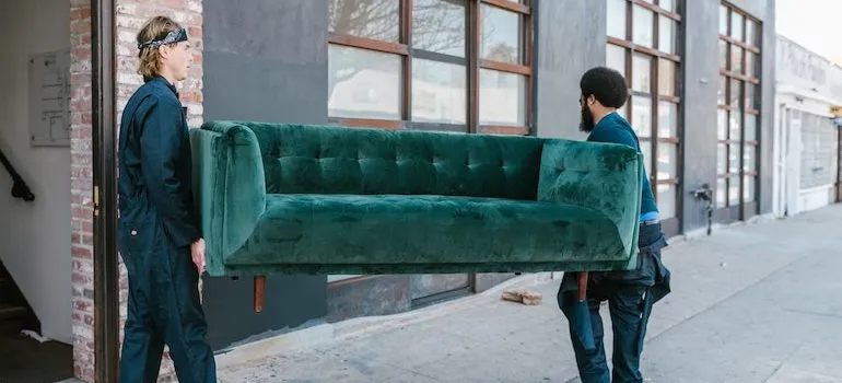 two men carrying a sofa 