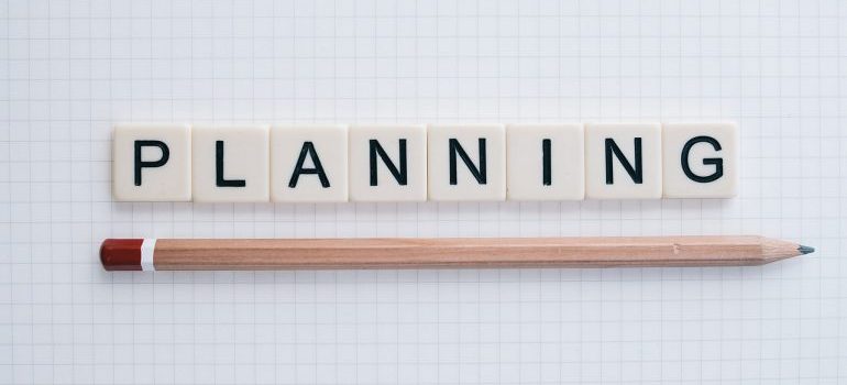 Cubes spelling the word planning and a pencil below it.