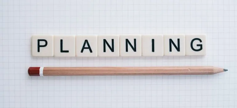 Cubes spelling the word planning and a pencil below it.