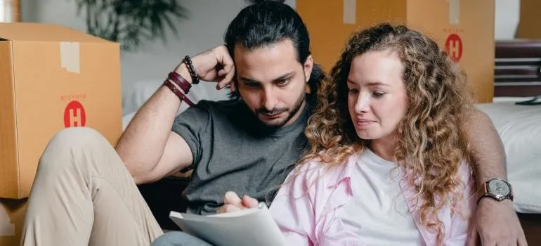 A young couple devising a plan to protect furniture when moving
