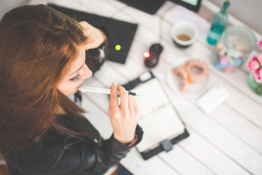 A woman siting at a table with her planner - self-organization makes relocation easier