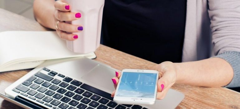 A person in an office with a laptop and a phone