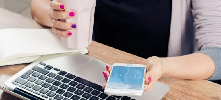 A person in an office with a laptop and a phone 