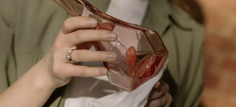 A woman cleaning a glass bottle