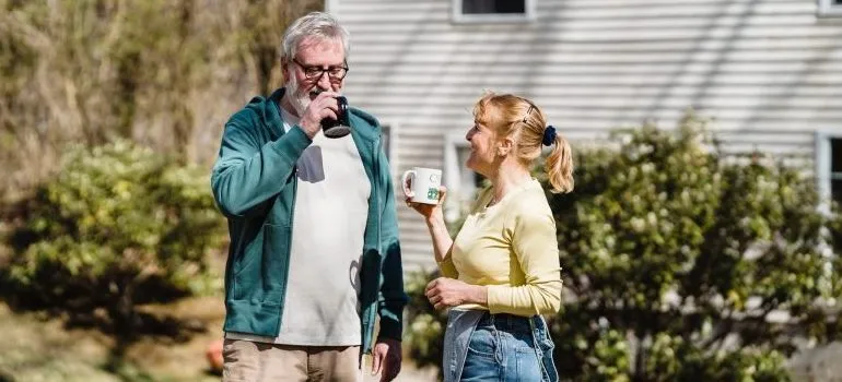 two people drinking something, outside