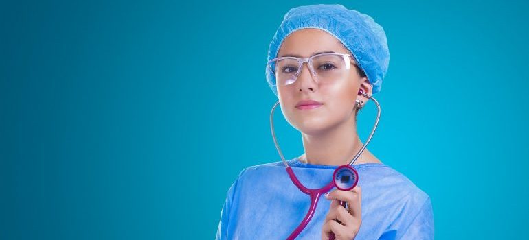 A female doctor holding a stethoscope - find one to help your parents relocate overseas.