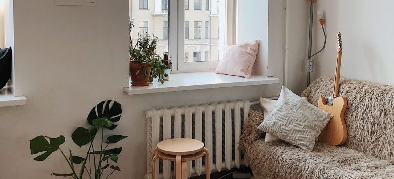 Empty apartment with sofa, coffee table and guitar