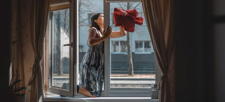 person cleaning a large window