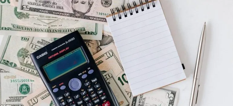 dollar bills, notepad, pencil and a calculator