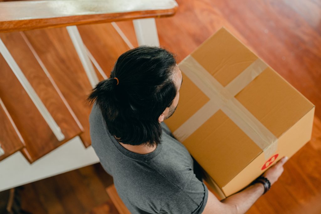 man carrying a cardboard box