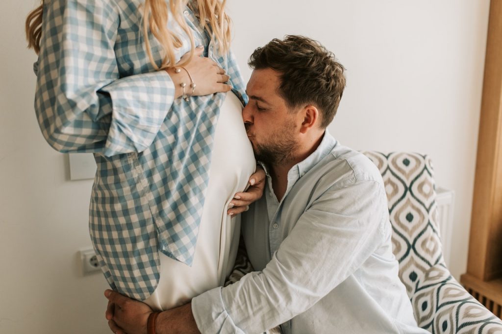 The man kissing the pregnant belly
