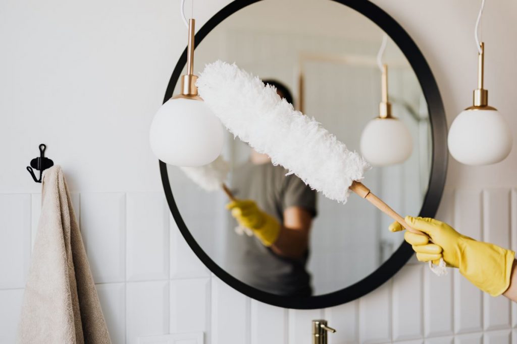 person cleaning a mirror
