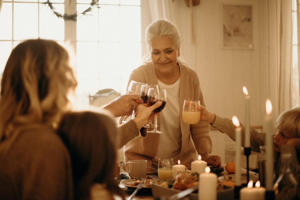 Elderly woman making a toast with family and friends.