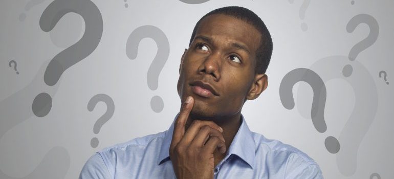 A man surrounded by question marks.