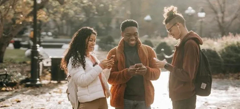A group of young people walking in the park.
