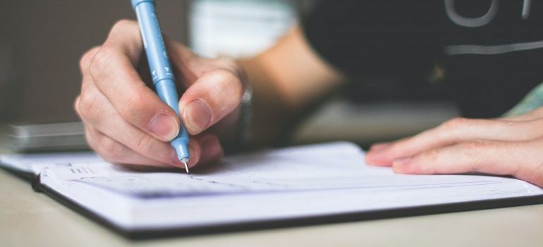 A person is writing in a notebook