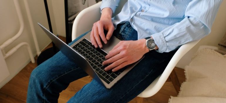 A man reading reviews because that makes it easier to choose between moving companies.