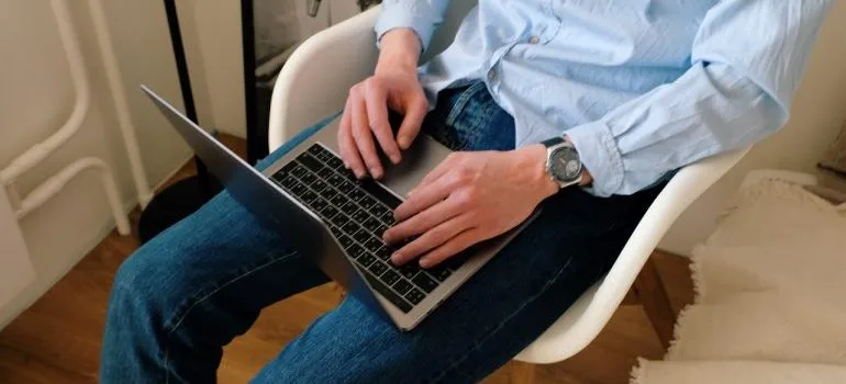 A man reading reviews because that makes it easier to choose between moving companies.
