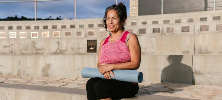 woman holding a yoga mat