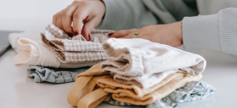 person packing clothes for moving into assisted living
