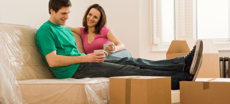 couple relaxing in their new home after a successful relocation with the help of professional movers