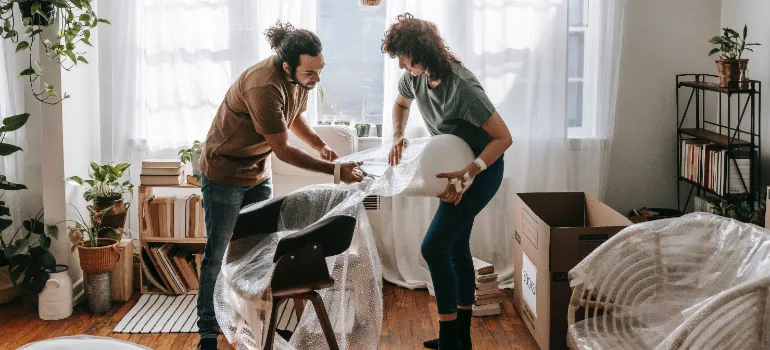 two people packing furniture when moving