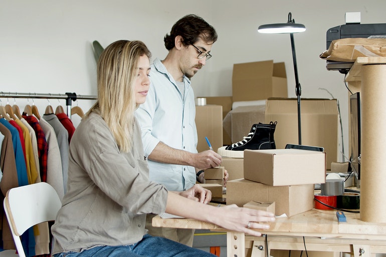 A man and a woman packing before moving to a new office.